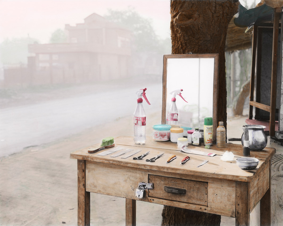 Vasantha Yogananthan, Barbershop, Ayodhya, India, 2015. Black and white C-print hand-painted by Jaykumar Shankar. From the series A Myth of Two Souls (2013-2021). On loan from the artist.