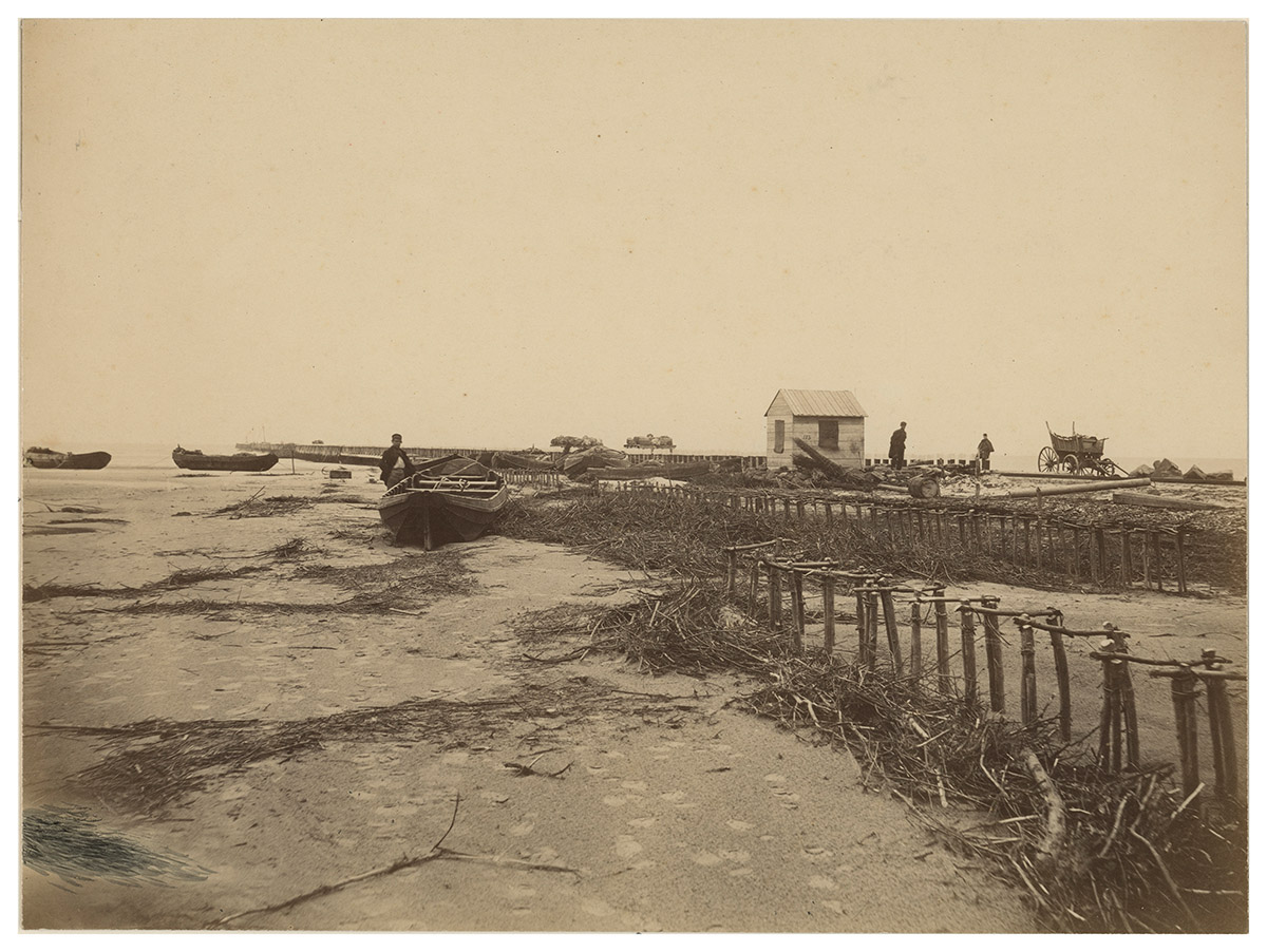 Waterweg van Rotterdam naar zee, de aanleg van het noordelijk havenhoofd, 1869<br>
Jacobus van Gorkom jr. / Collectie: Stadsarchief Rotterdam<br>
Houten palen, rijswerken, heien met menskracht, steenzetten: met primitieve middelen probeerden Caland, de aannemers en hun arbeiders de stroom te leiden en letterlijk naar de hand te zetten. Het is niet bekend hoeveel arbeiders bij dit enorme werk zijn ingezet. Wel dat het uiteindelijk een triomf en doorbraak was voor de nu wereldberoemde natte aannemerij. Zo was het bedrijf Van Oord van oorsprong gespecialiseerd in rijswerk, dat wil zeggen het maken van constructies van wilgenhout en andere sterke en buigzame houtsoorten. Adriaan Volker (grondlegger van Volker Wessels Stevin) en Janus Bos (Boskalis) grepen hun kans toen er bij de Nieuwe Waterweg gebaggerd moest worden.