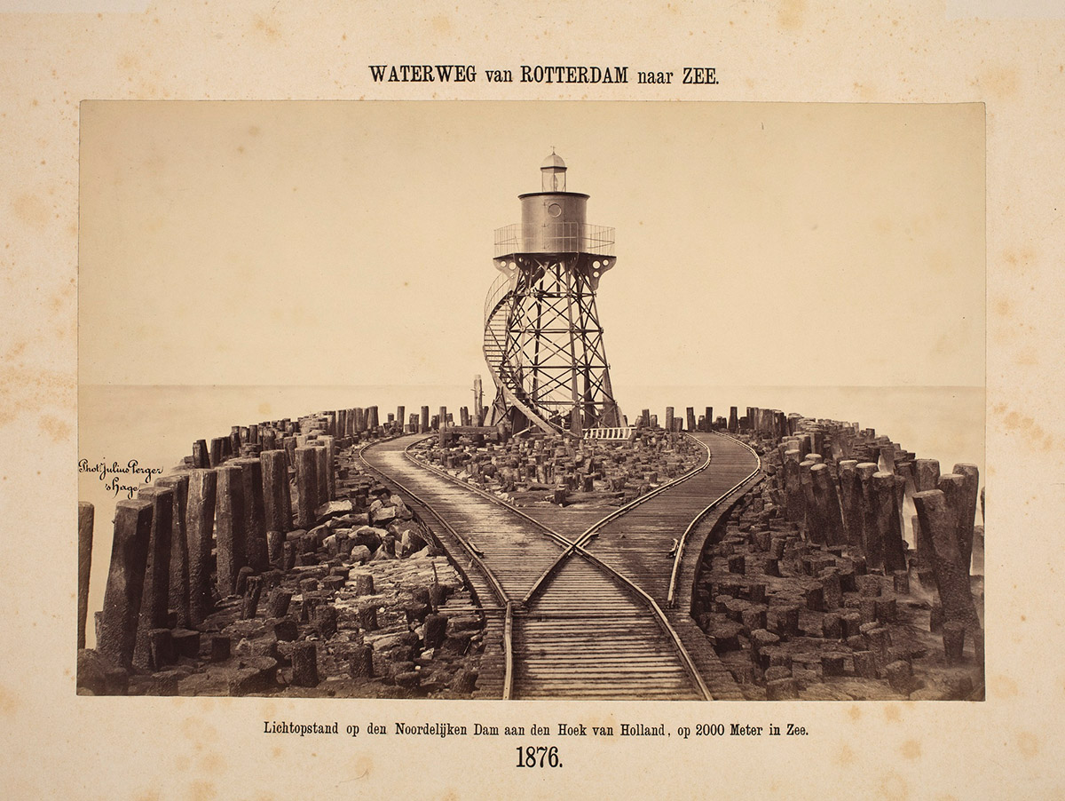 Lichtopstand aan het einde van de noordelijke dam, 1876<br>
Julius Perger / Collectie: Koninklijke verzamelingen<br>
In 1876 werd op het einde van de twee kilometer lange noordelijke dam als baken voor de scheepvaart een lichtopstand geplaatst, rustende op een houten fundering. Niettemin deden zich vaak ongelukken voor. In 1895 verdween het gietijzeren gevaarte bij een storm in de golven. In de daaropvolgende jaren is de bebakening sterk verbeterd.