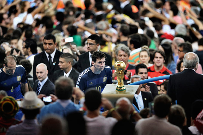Bao Tailiang, China, Chengdu Economic Daily, First Prize Sports Category, Singles. Rio de Janeiro, Brazil, Argentina player Lionel Messi comes to face the World Cup trophy during the final celebrations at Maracana Stadium. His team lost to Germany 1-0, after a goal by Mario G&ouml;tze in extra time.