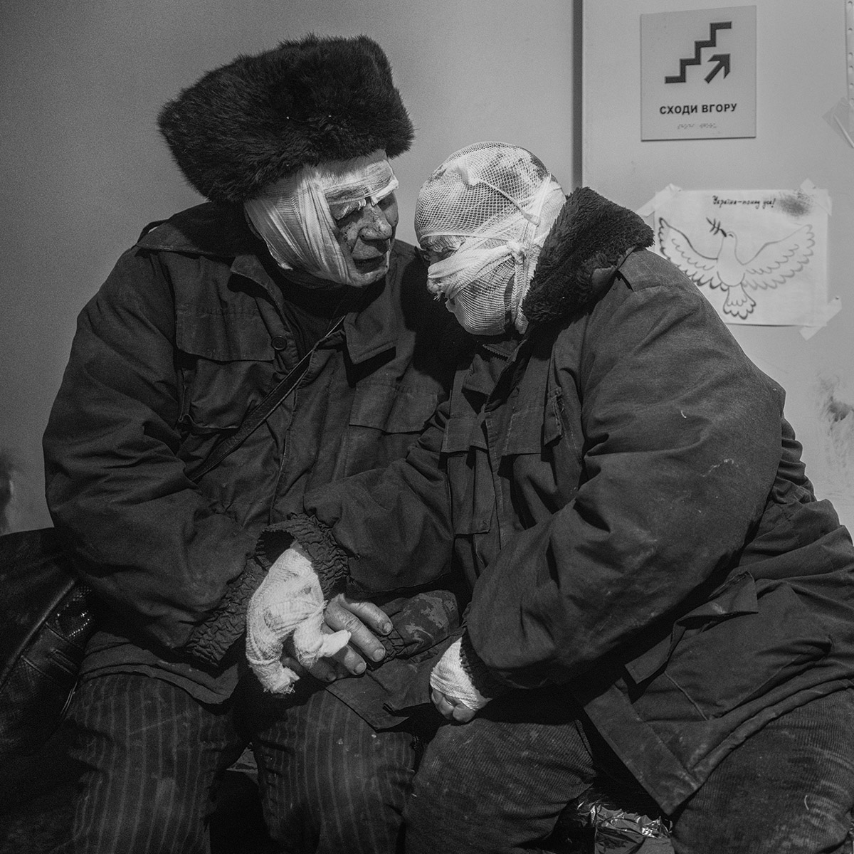 Een gewond bejaard echtpaar, Lydia Rakitska en Volodymyr Rakitsky, zoeken steun bij elkaar in een kliniek in Bachmoet, nadat een Russische raket hun huis vernietigde (foto Eddy van Wessel)